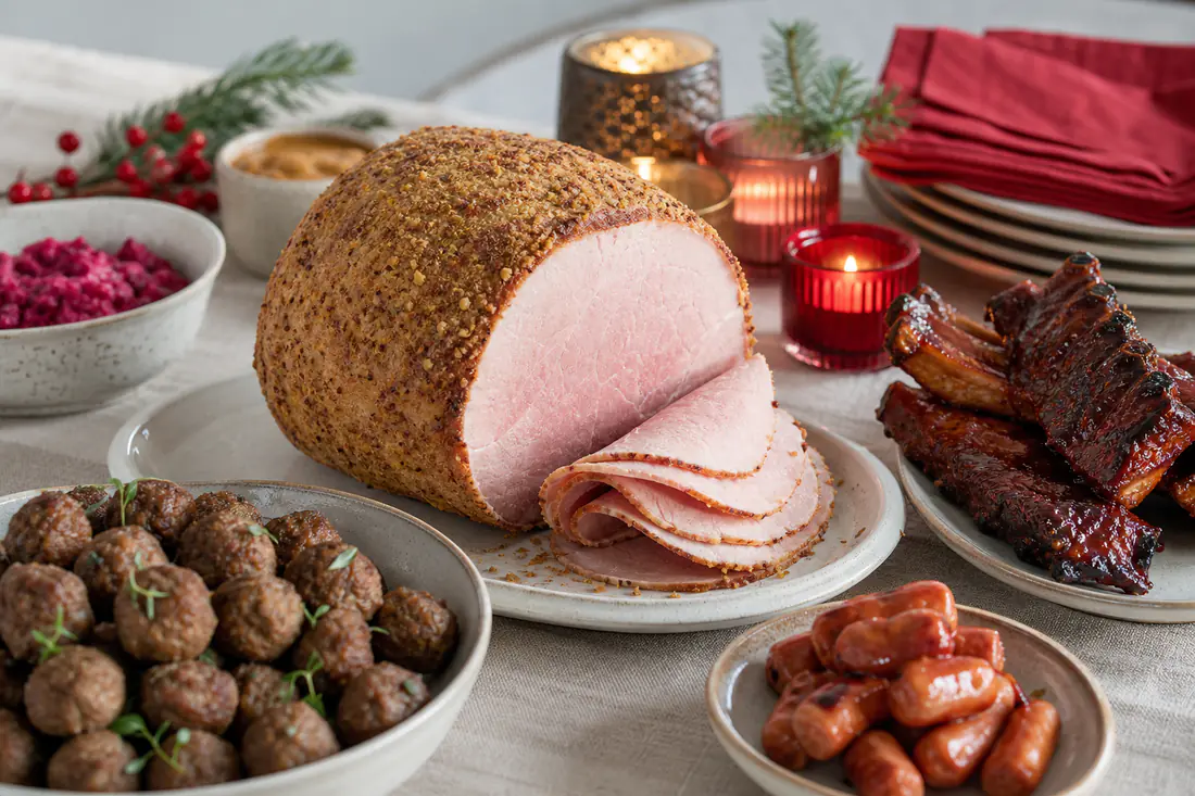 Julbord med griljerad julskinka, köttbullar, prinskorv och glaserade revbensspjäll